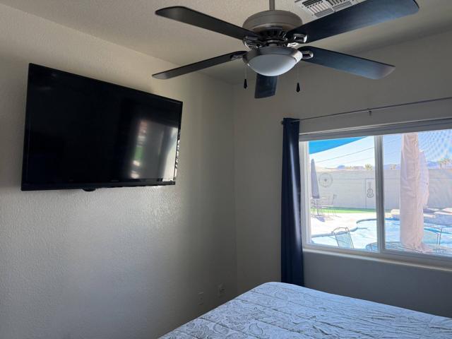 Bedroom: Flat screen TV and a view of the pool from the bedroom window.